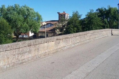 Cruzando el puente de siete ojos sobre el río Arlanza se llega a la localidad.-ECB