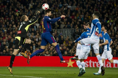 Gerard Piqué cabecea un balón, ante el Espanyol.-JORDI COTRINA