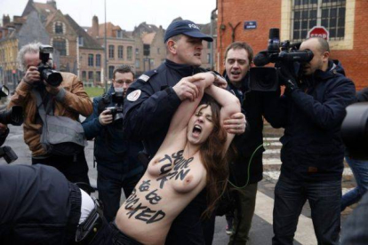 La policía francesa se lleva a rastras a una de las activistas de Femen que ha asaltado el vehículo de Strauss-Khan a su llegada al juzgado, este martes.-Foto: REUTERS / PASCAL ROSSIGNOL