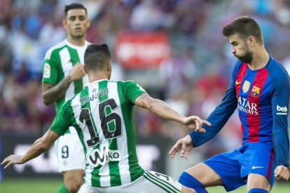 Piqué, junto a Cejudo, en el Barça-Betis de la primera jornada.-JORDI COTRINA