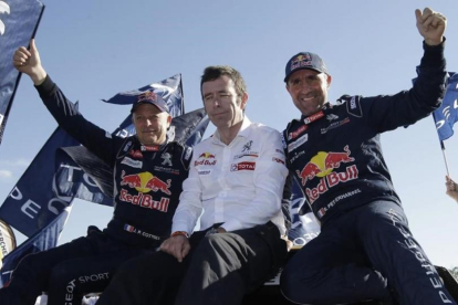 Stéphane Peterhansel, a la izquierda, junto al jefe de Peugeot, Bruno Famin, y su copiloto Jean Paul Cottret.-AP / MARTÍN MEJÍA