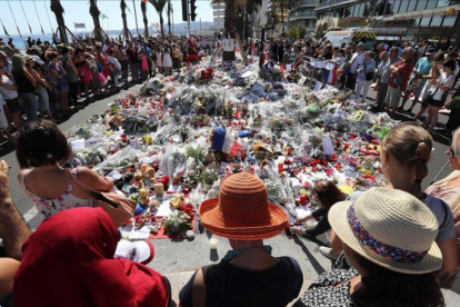 Centenares de personas se reúnen alrededor de las flores situadas en el Paseo de los Ingleses para homenajear a las víctimas-VALERY HACHE