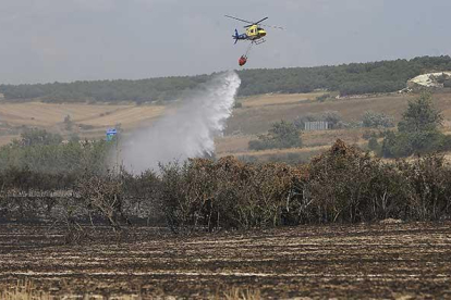 Un helicóptero trabaja sobre la zona del incendio declarado ayer en el entorno de Villatoro.-RAÚL G. OCHOA