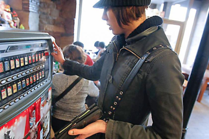 Una mujer compra tabaco en una máquina instalada en un bar.-ECB