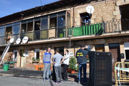 La Policía Judicial realiza su trabajo de investigación. Al lado, vecinos afectados esperando a recuperar algunos de sus muebles.-R.F.