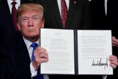 Donald Trump muestra su firma en el mermorándum sobre China. /-JONATHAN ERNST