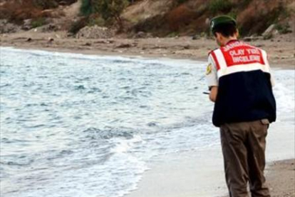 El niño sirio Aylan Kurdi, ante un guardacostas en la playa de Turquía a la que llegó su cadáver.-REUTERS / NILUFER DEMIR