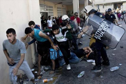 La policía reprime a refugiados en el puerto de Mitilene, ayer.-Foto: AFP / ANGELOS TZORTZINIS