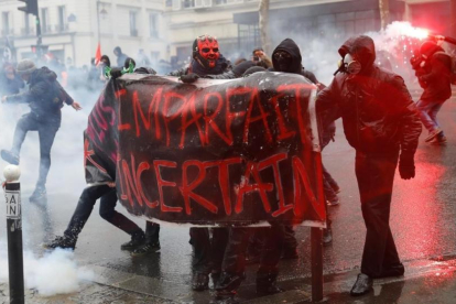 Manifestantes se enfrentan con la policia antidisturbios durante la huelga general en París.-/ EFE / YOAN VALAT