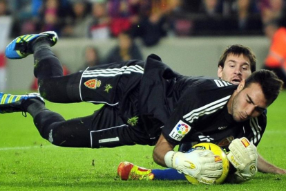 Roberto, ante Messi, en la temporada 2011-12, cuando el portero jugaba en el Zaragoza.-AP / MANU FERNÁNDEZ