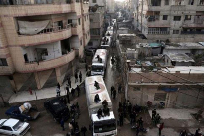 Convoy de ayuda humanitaria por las calles de Kafr Batna.-AFP / AMER ALMOHIBANY
