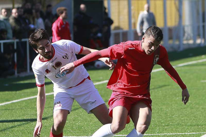El jugador del Real Burgos Taborda protege el balón ante la presión del delantero del Atrio, Guti, ayer.-RAÚL OCHOA