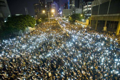 Manifestantes estudiantiles sostienen sus teléfonos  en una muestra de solidaridad durante las protestas frente a la sede del Consejo Legislativo de Hong Kong.-Foto: AFP / XAUME OLLEROS