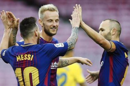 Rakitic e Iniesta felicitan a Messi tras uno de sus goles al Las Palmas.-EFE / ALEJANDRO GARCÍA