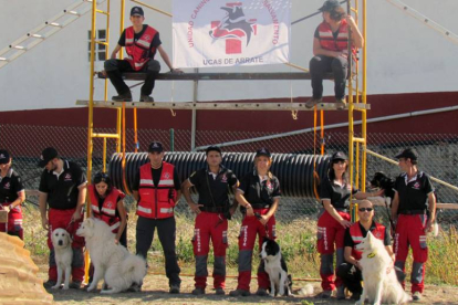Los instructores de la Unidad Canina de Rescate posan orgullosos con sus perros, héroes caninos cuya ayuda es inestimable.-UCAS