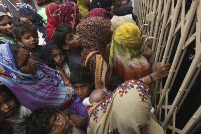 Familias paquistanís esperan en la entrada de un hospital para realizarse las pruebas de VIH.-FAREED KHAN (AP)