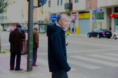Un hombre pasea por Gamponal con su pantalla protectora casera. RAÚL OCHOA