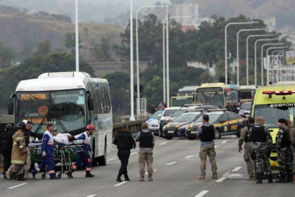 Una rehén es atendida por personal sanitario tras ser liberada por el secuestrador que la retenía en un autobús en el puente Rio-Niterói.-ANTONIO LACERDA (EFE)