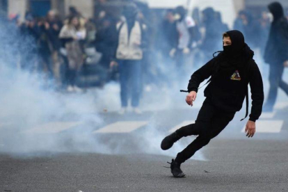 Un manifestante huye de los gases disparados por la policía.-AFP / LIONEL BONAVENTURE