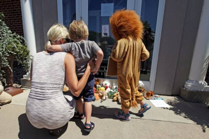 Niños lloran la muerte de Cecil, ante la puerta de la clínica del dentista que lo mató, en Bloomington (Minneápolis).-Foto:   ERIC MILLER / REUTERS