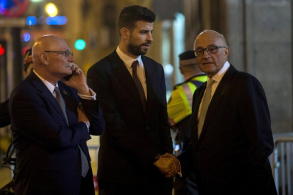 Gerard Piqué (c) saluda al presidente del Banco de Sabadell, Josep Oliu (d), en presencia del CEO y consejero delegado del GSMA, John Hoffman (i) tras la cena de bienvenida al Mobile World Congress (MWC).-QUIQUE GARCÍA (EFE)