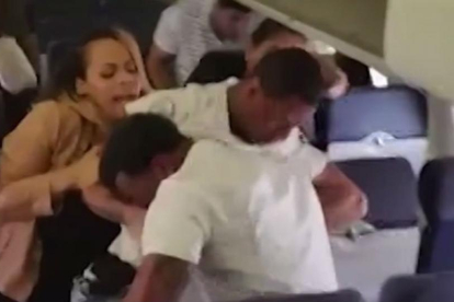 Una mujer intenta separar a los dos individuos que se enzarzaron en un avión de Southwest.-CNN