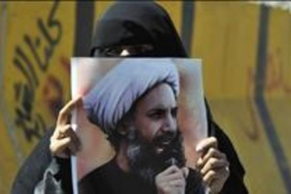 Una mujer sostiene en Yemen la foto del clérigo chií Al Nimr ajusticiado.-EFE / YAHYA ARHAB