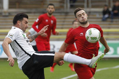 Adrián pugna por un balón junto a un adversario durante un encuentro disputado en El Plantío.-SANTI OTERO