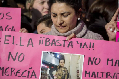 Una mujer sujeta una pancarta durante una protesta para erradicar la lacra social que representa la violencia de género.-ALBERTO DI LOLLI