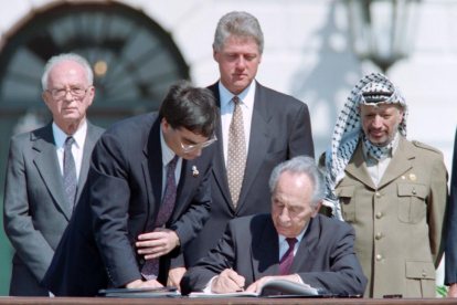 Peres firma los acuerdos de Oslo, observador, de izquierda a derecha, por Isaac Rabin, Bill Clinton y Yasir Arafat, el 13 de septiembre de 1993.-AFP / J. DAVID AKE