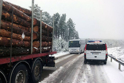 Un camión y un autobús escolar esperan a que la Guardia Civil acondicione el terreno para continuar su camino.-ECB