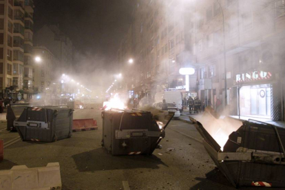 Primera noche de disturbiso, con contenedores quemados y cristales de sucursales bancarias reventados.-SANTI OTERO