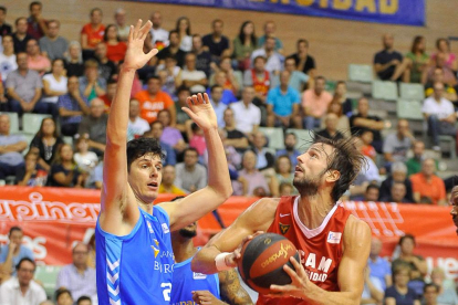 Huskic intenta frenar al jugador del Murcia Delía.-ACB PHOTO / J. BERNAL
