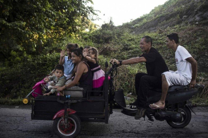 Inmigrantes hondureños montados en una moto-PEDRO PARDO / AFP