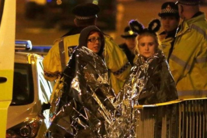 Dos chicas son atendidas por los servicios de emergencia a las afueras del Manchester Arena.-REUTERS