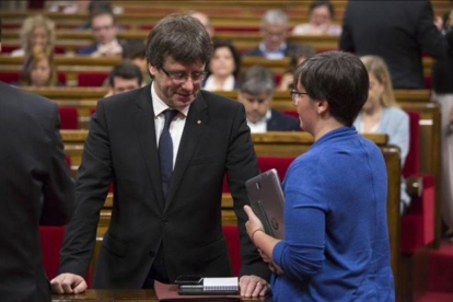 El presidente de la Generalitat, Carles Puigdemont, y la diputada de la CUP Mireia Boya, en el Parlament.-ALBERT BERTRAN