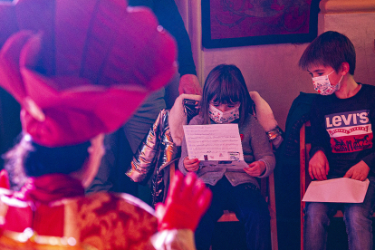 Una niña lee su carta a los Reyes Magos ante los emisarios del Rey Melchor que reciben a los pequeños en el Salón Rojo. ISRAEL L. MURILLO