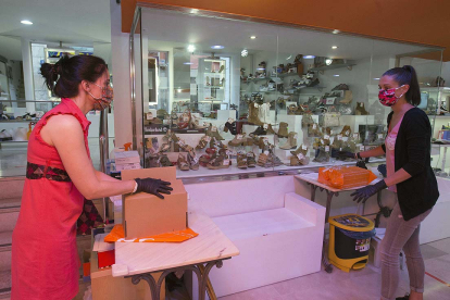 Dos empleadas de Calzados Vesga, en la Plaza Mayor, preparan los pedidos online. RAÚL. G. OCHOA