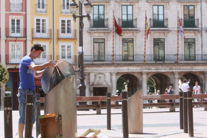 Un hombre deposita la basura en un contenedor ubicado en la Plaza Mayor.-RAÚL G. OCHOA