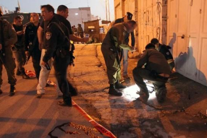 La policía israelí trabaja en el lugar donde cayó mal herida la adolescente palestina en Hebrón.-AFP / HAZEM BADER