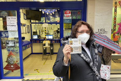 Los más rezagados ultiman la compra de sus décimos para el sorteo del 22 de diciembre, esta mujer lo hace en la administración de lotería de la calle Mantería, en el centro de Valladolid. - J.M. LOSTAU