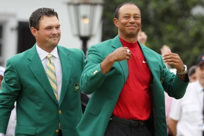 Tiger Woods recibe la chaqueta verde del anterior ganador Patrick Reed en la ceremonia del Masters.-LUCY NICHOLSON (REUTERS)