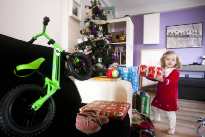 Una emocionada niña abriendo los regalos, entre ellos una bici adaptada a su edad, que le dejaron os Reyes Magos en sus zapatos la noche del 5 de enero.-SANTI OTERO
