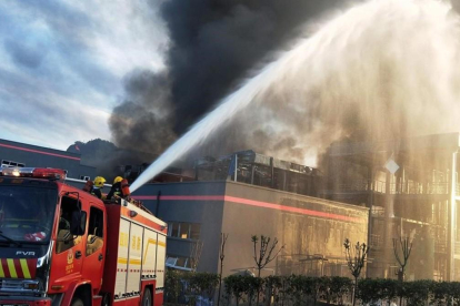 Los bomberos durante las tareas de extinción del incendio, este jueves en China.-STR