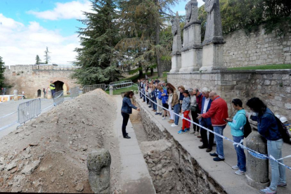 Un grupo de personas atiende a las explicaciones de Monzón sobre las excavaciones.-ISRAEL L. MURILLO