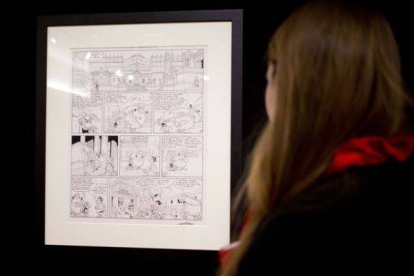 Una mujer mira la plancha de Astérix subastada a beneficio de los familiares de los dibujantes de 'Charlie Hebdo'.-Foto: AFP / KENZO TRIBOUILLARD