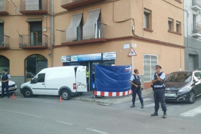 Agentes de los Mossos custodian la puerta de un locutorio de Ripoll registrado en relación con los atentados de Barcelona y Cambrils.-GERARD VILA (ACN)