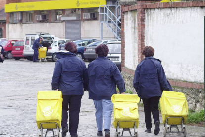 Tres trabajadoras de correos entrando con sus carros a las instalaciones de la entidad en la capital.-ISRAEL L. MURILLO