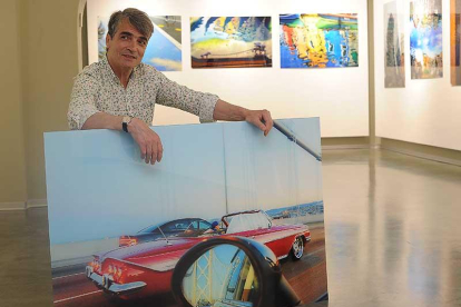 Javier Contreras posa con una de las imágenes que componen esta muestra. Al fondo, otro puñado más, con su reflejo en el suelo.-Israel L. Murillo