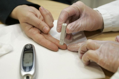 Un sanitario realiza la prueba de medición de glucosa a un paciente.-SANTI OTERO